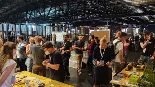 Teilnehmer*innen des Makerspace stehen vor gelben Tischen in der Haupthalle der re:publica 22