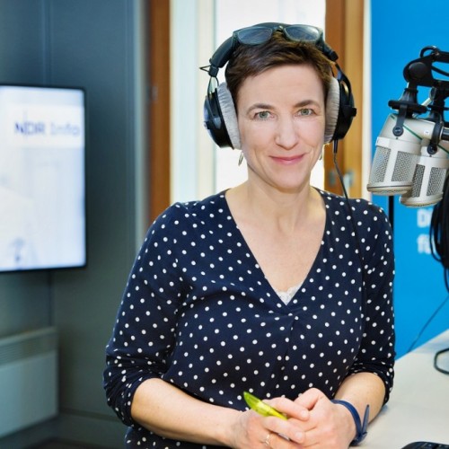 Korinna Hennig im Podcast - Studio sitzend mit Kopfhörern an