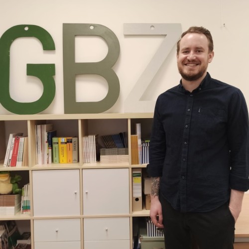 A person standing next to a "GBZ" sign